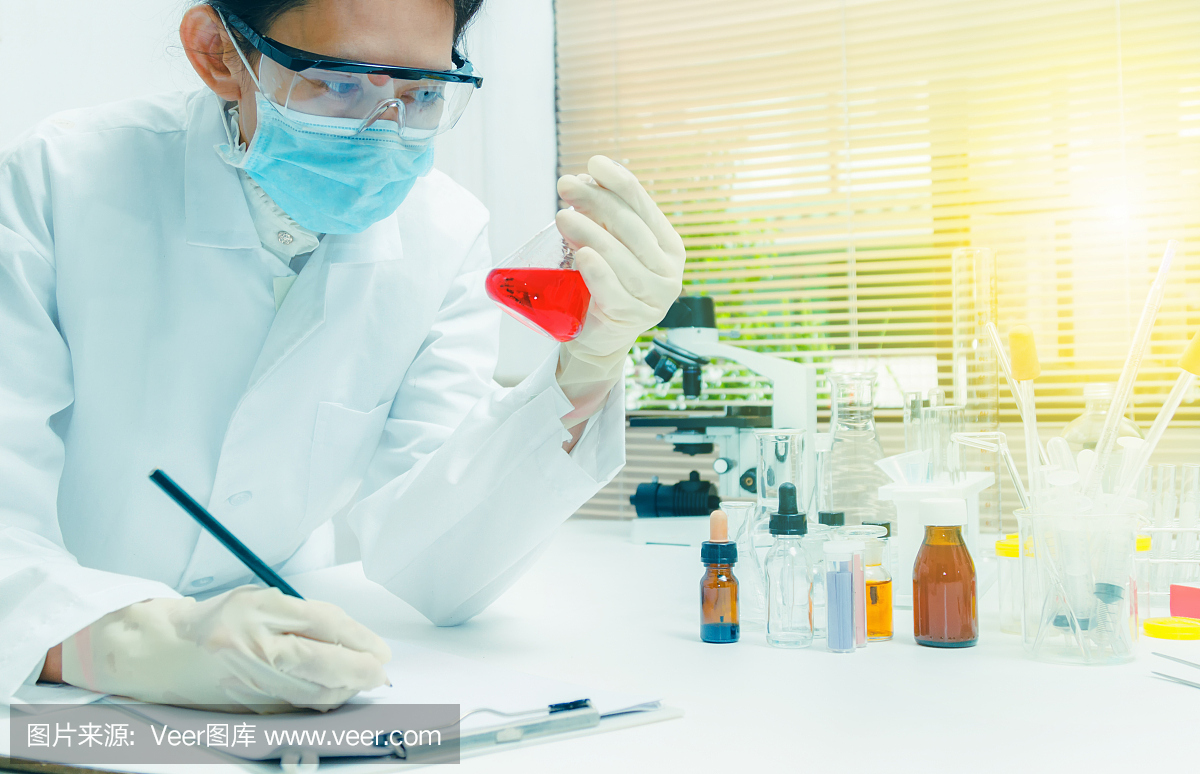 科学家带着设备和科学实验,实验室玻璃器皿含有化学液体,科学研究,科学背景和科学概念和选择性的重点。